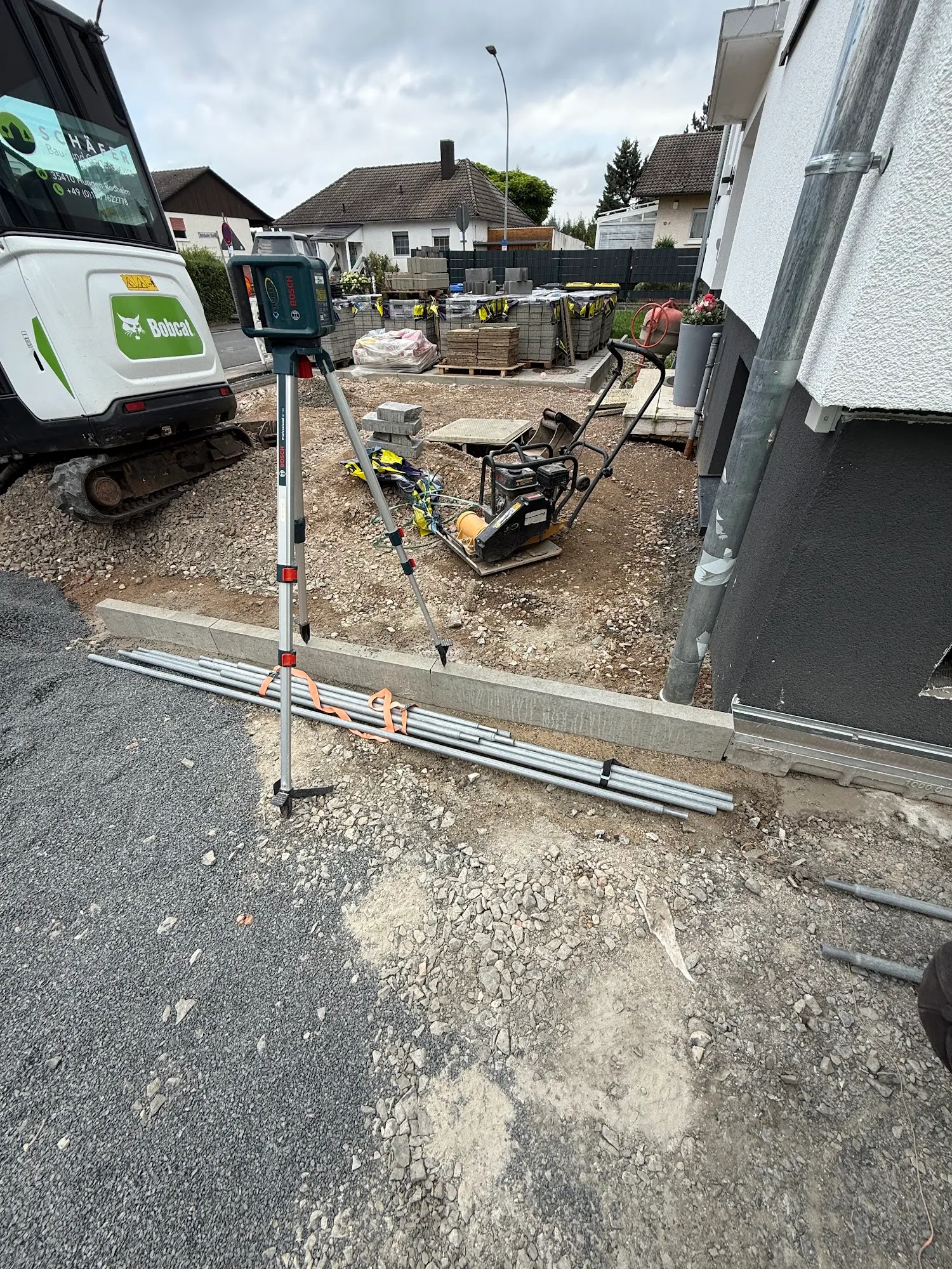 Bobcat Minibagger und Rotationslaser bei Erdarbeiten und Geländemodellierung