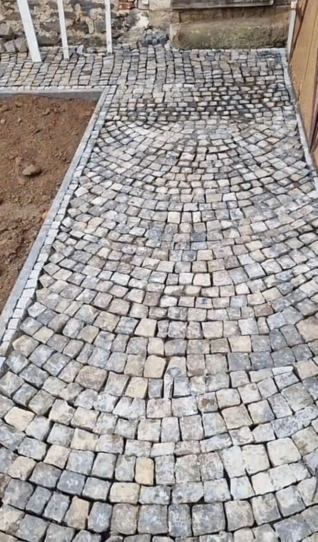 Fertige Segmentbogen-Pflasterung aus Granit-Kleinsteinen mit Randeinfassung